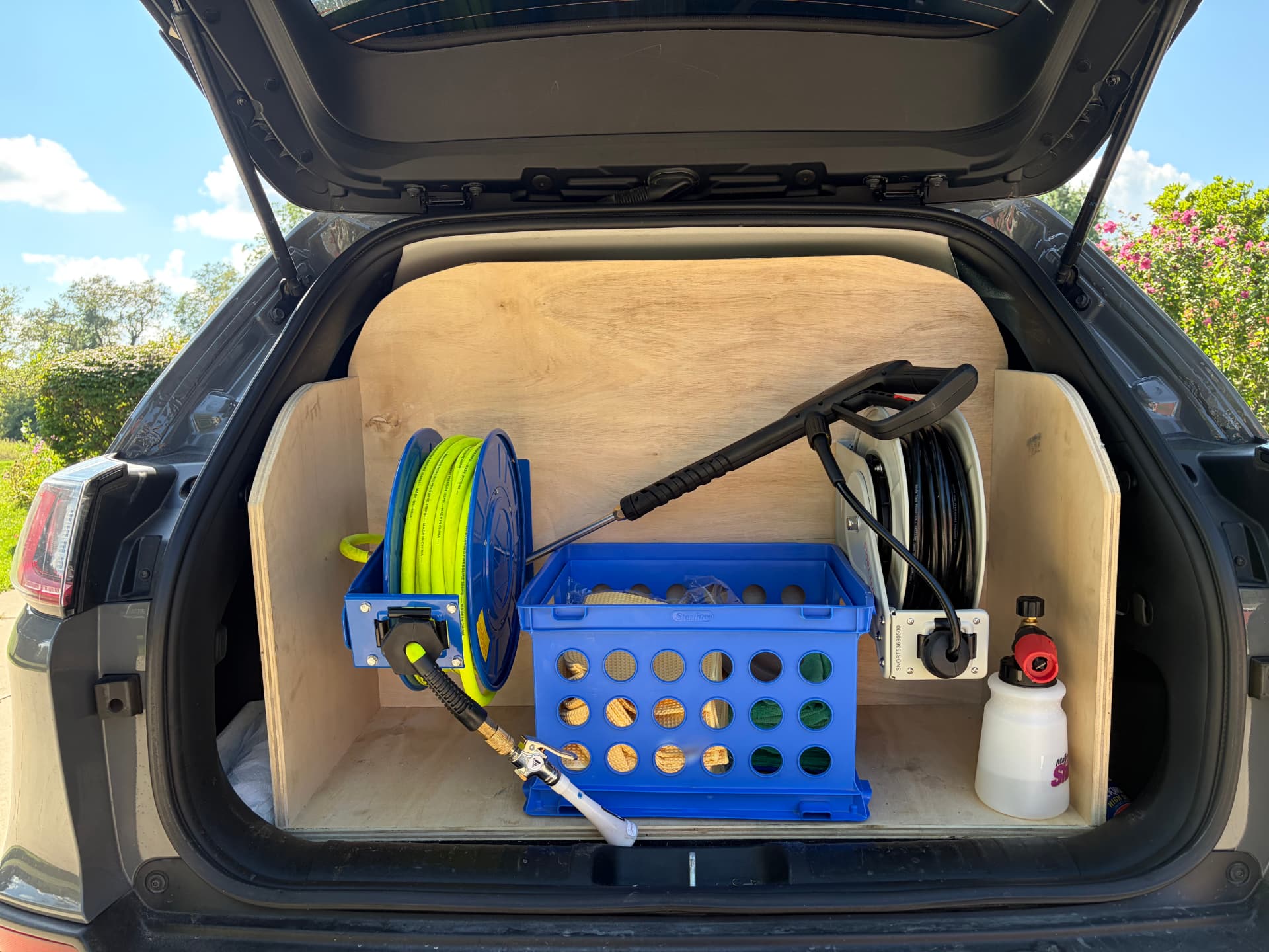 Custom-built trunk setup — pressure washer, hose reels, and foam cannon ready to go